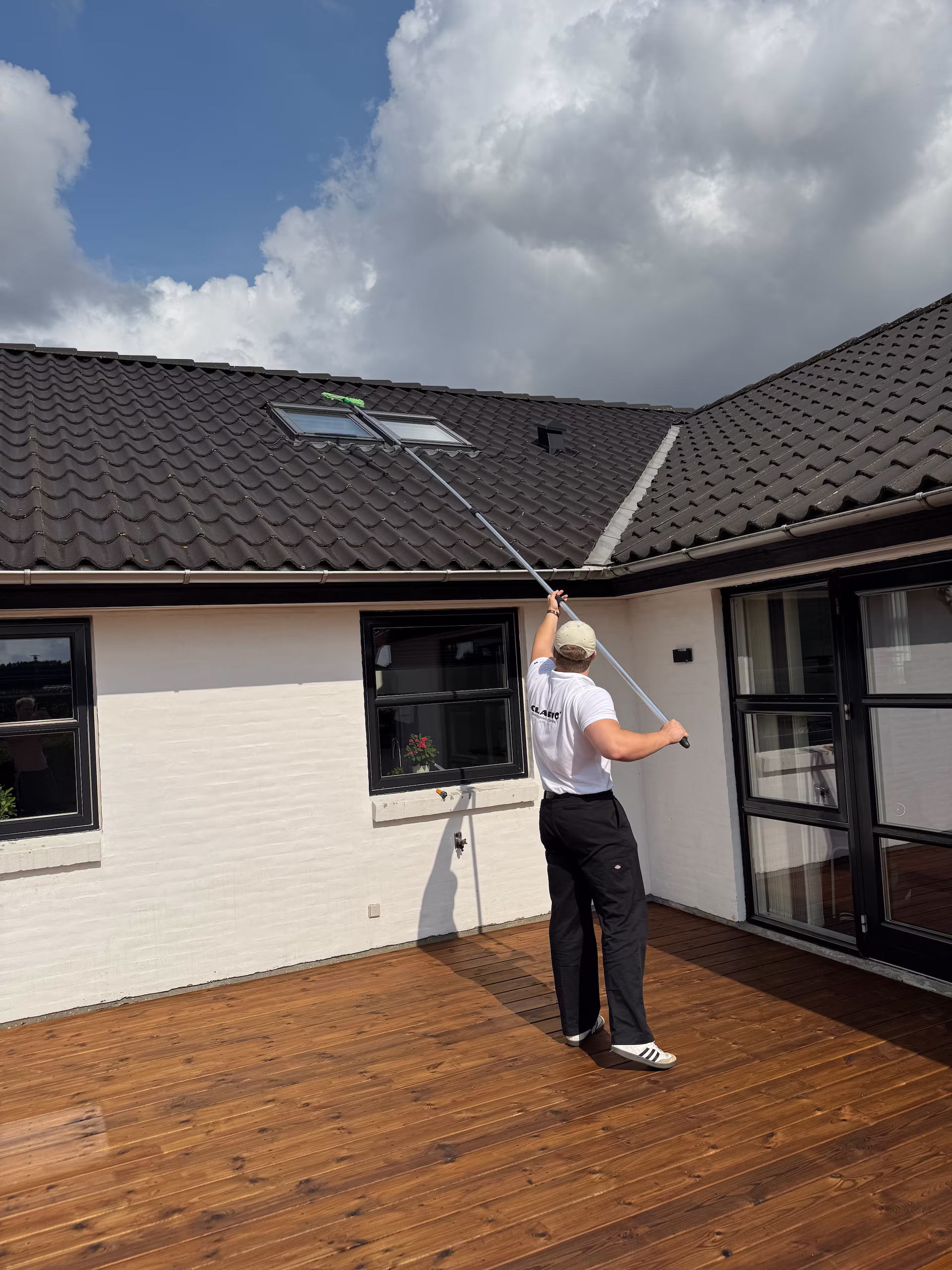 Vinduespudser bruger teleskopstang til at pudse høje vinduer